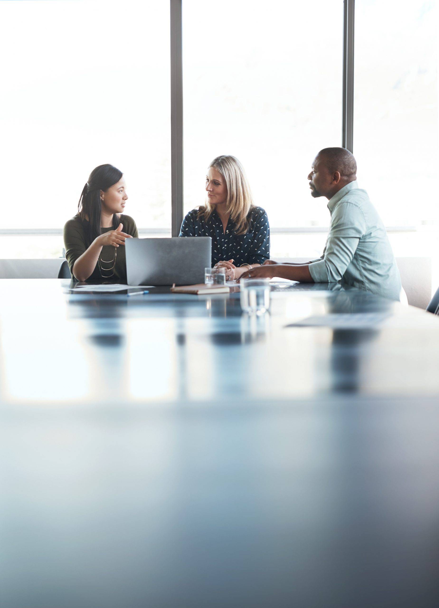 Three people meet at a conference table in front of a window, with a laptop and water glasses in front of them. Shaffer & Shaffer lawyers in Charleston help people across West Virginia.