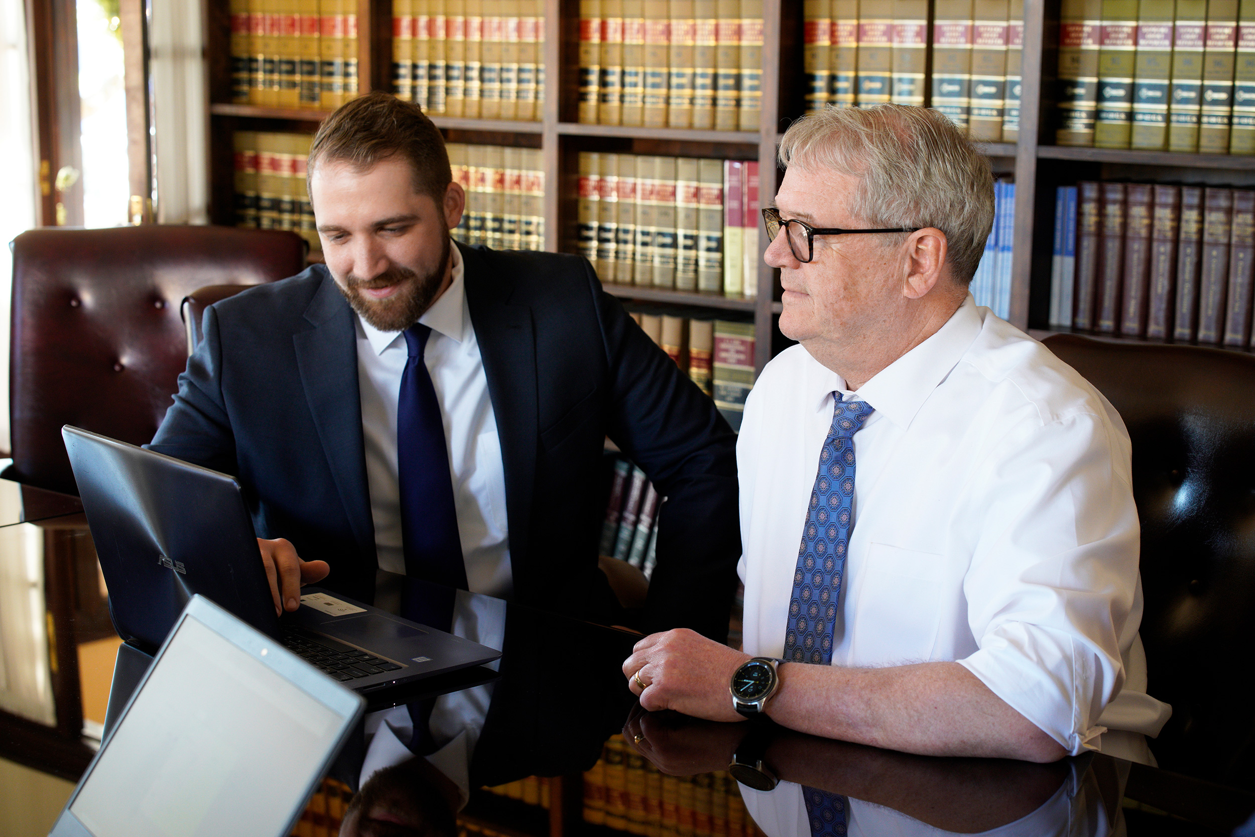 West Virginia lawyers Ryan Walters and Chip Shaffer from Shaffer & Shaffer at a conference table in front of a laptop, law books behind them. We provide answers to your personal injury questions.