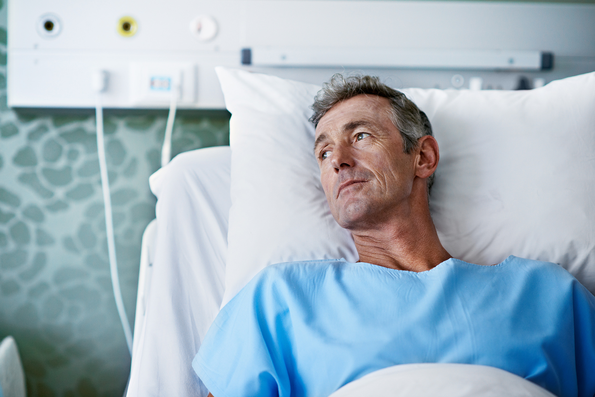 A man reclining in a hospital bed looks toward the light from a window. Shaffer & Shaffer has medical malpractice lawyers in West Virginia.