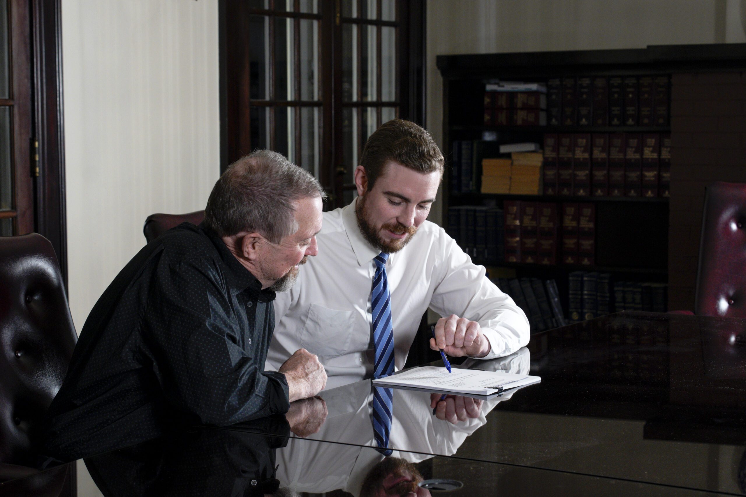 West Virginia personal injury lawyer Alex Meade meets with a client at a table in the Shaffer & Shaffer offices. You can bring multiple types of injury cases to our firm.