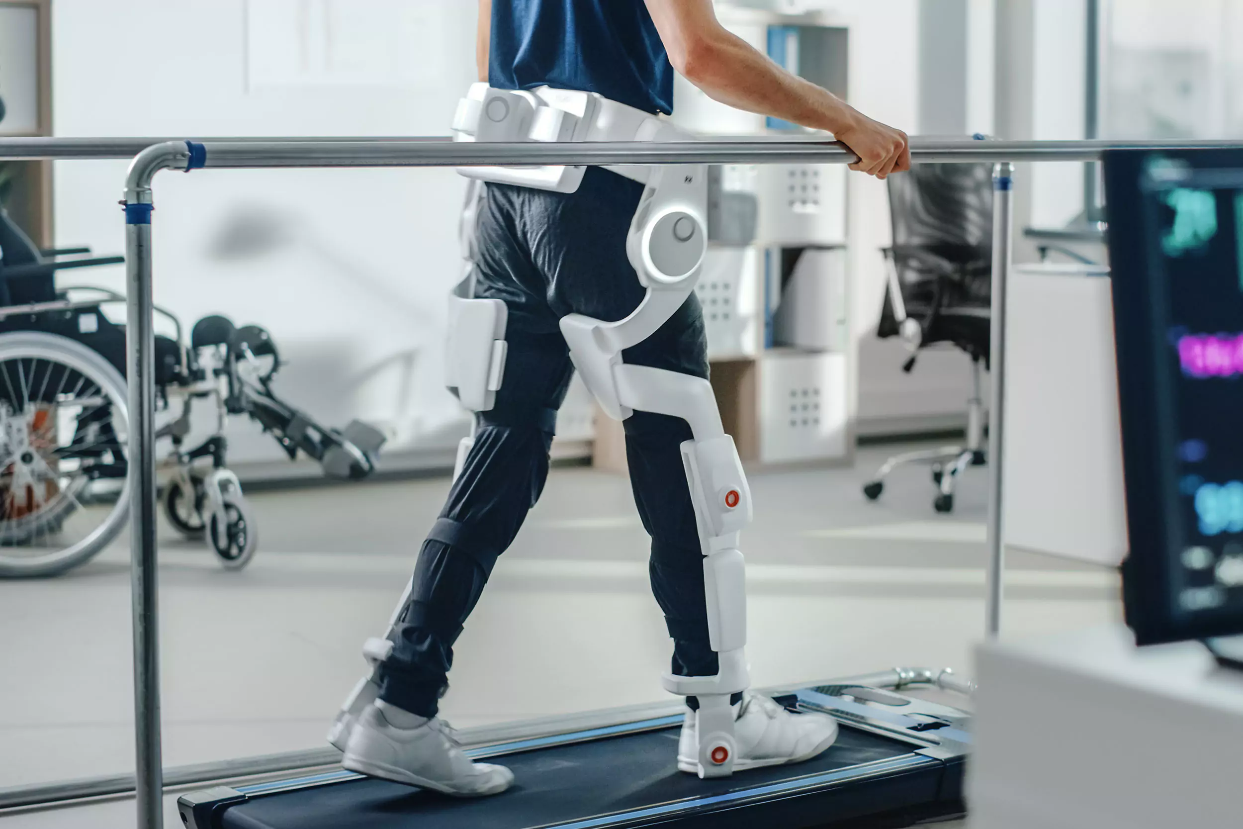 Modern Hospital Physical Therapy: Patient with Injury Walks on Treadmill Wearing Advanced Robotic Exoskeleton Legs. Physiotherapy Rehabilitation Technology to Make Disabled Person Walk. Focus on Legs